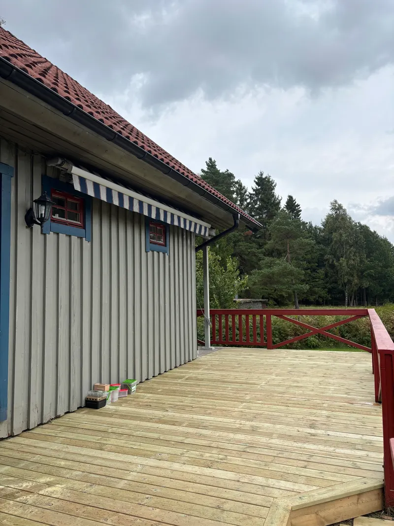 Ny trall längs ett grått trähus